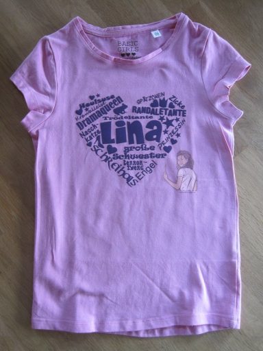 Rosa T-Shirt mit Herzen und dem Namen "Lina" in blauen Buchstaben.