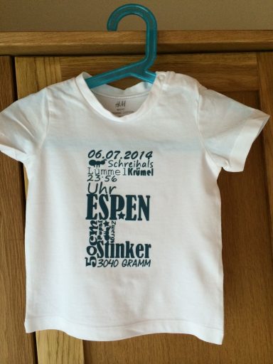 Weißes Kinder-T-Shirt mit blauem Text und Namen "ESPen" sowie Geburtsdatum.