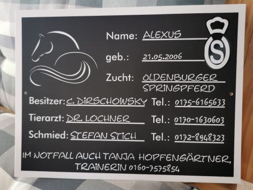 Schwarzes Schild mit Informationen über ein Pferd, einschließlich Name und Zucht.