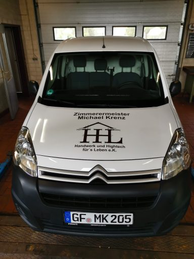 Weißer Transporter mit Logo und Schriftzug "HL" auf der Front.