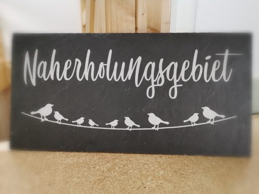 Schild mit der Aufschrift "Naherholungsgebiet" und stilisierten Vögeln.