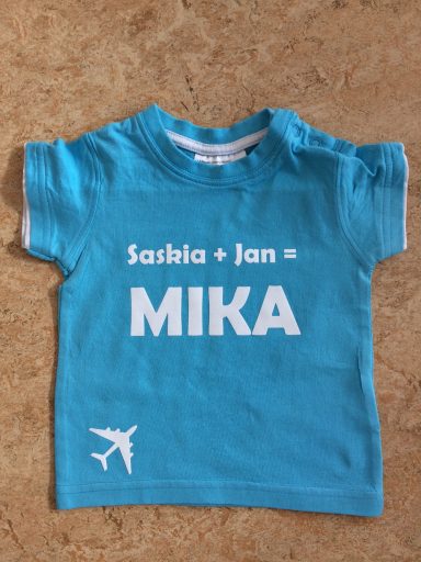 Blaues T-Shirt mit den Namen "Sascha + Jan" und dem Wort "MIKA" in großen weißen Buchstaben.